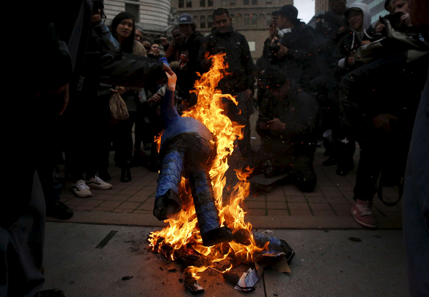 Protesters burn a Donald J. Trump piñata in Frank Ogawa Plaza during an anti-Trump protest on the evening of his presidential inauguration Jan. 20, 2017 in Oakland, Calif.