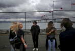 Friends, from left, Angelica Roessert, 21, (not visible) Jennifer Lee, 21, Alex Dernoncourt, 19, Jessica Hanes, 22, and Alan Martinez, 22, hang out and pose for photos with the Bay Bridge in the background as storm clouds approach during first day of the Treasure Island music festival Oct. 15, 2016 in San Francisco, Calif.