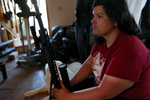 Bonnie Nelson sits with Nelson’s rifle, nicknamed Yoko in the living room of the ranch house at the Tenacious Unicorn Ranch. Nelson, who used to be uncomfortable with guns, bought the rifle after witnessing Westcliffe’s July 4th protest in 2020, which featured some banners and flags that reminded Nelson and Logue of fascism. 