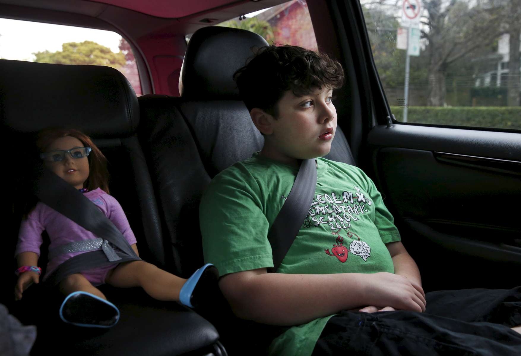 James Kaplan, 9, rides in the car with Brooks buckled in securely next to him with his younger sibling and mother on their way to host a rally for Gavin Grimm Feb. 15, 2017 in Berkeley, Calif. Grimm, a transgender teenager, sued the school board of his Virginia high school for the right to use the bathroom that corresponds with his gender identity. Sara Kaplan organized a rally that was one of many coordinated across the nation in support of Grimm before his case was to be seen by the Supreme Court. Ben, James' father, says that right after he transitioned, James stopped playing with his beloved dolls. It was not until his parents told him that just because he was a boy didn't mean he couldn't play with his dolls that he picked them back up again.