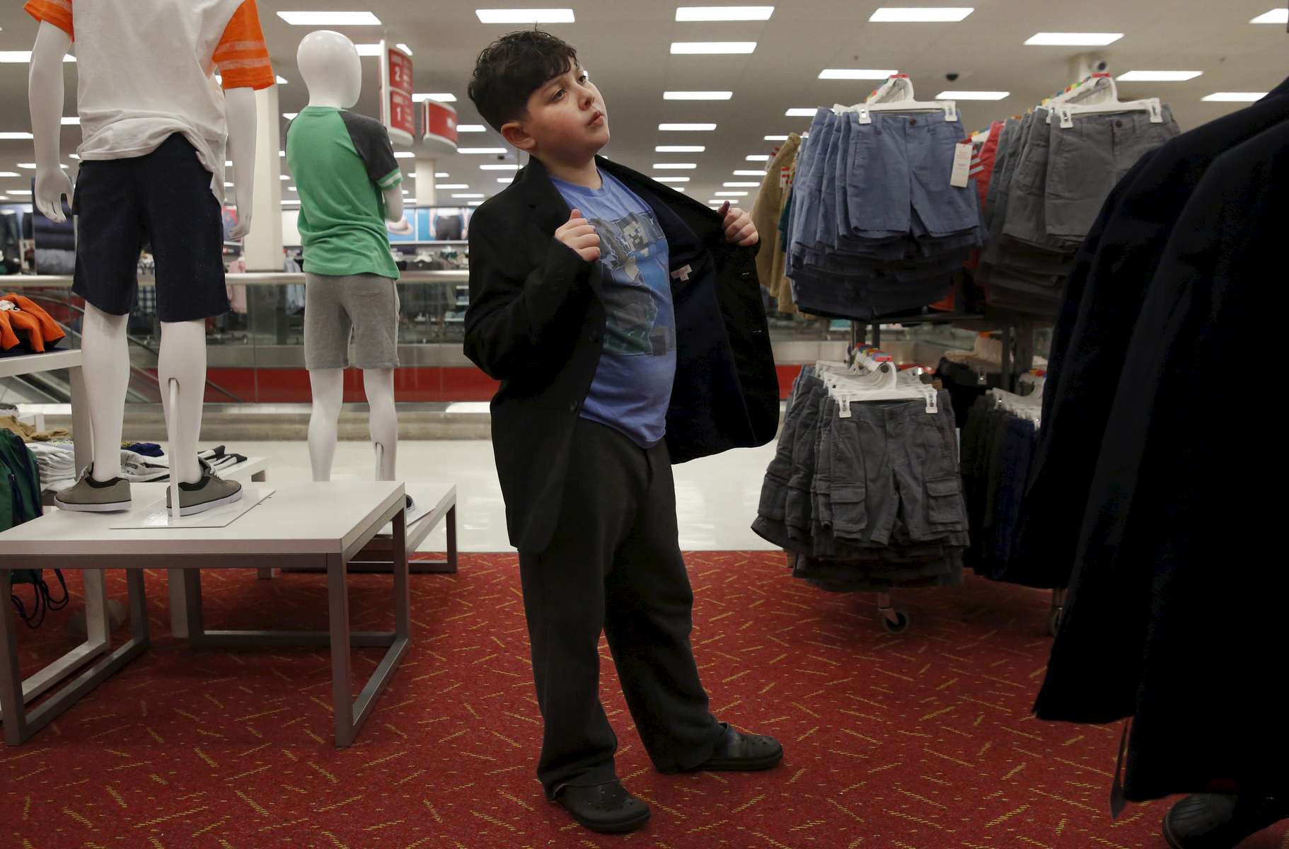 James Kaplan, 9, puts on a cool guy persona while trying on a new blazer during a shopping trip to Target for new clothes Feb. 17, 2017 in Berkeley, Calif. James vividly remembers the first time he went shopping with his mother in the boy's section of the store, it was an experience he had only dreamed about before he came out.
