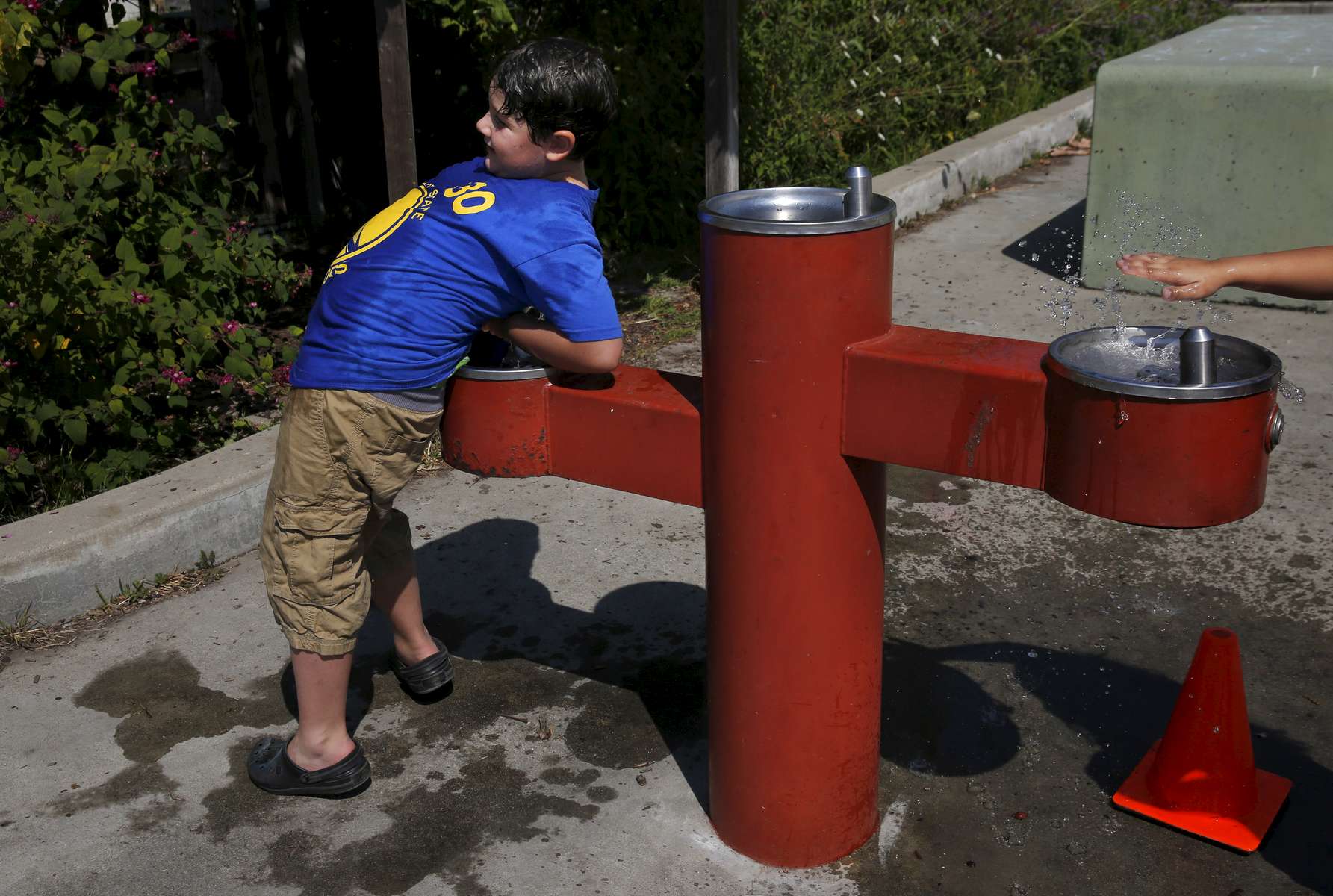 James Kaplan, 8, drenches his shirt in a water fountain while playing after school Sept. 7, 2016 in Berkeley, Calif.