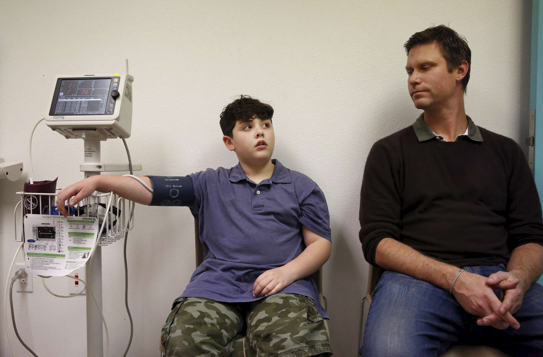  James Kaplan, 9, left, gets his vitals taken while sitting next to his dad Ben Kaplan during a medical appointment to determine if he is starting puberty at UCSF Benioff Children's Hospital's Child and Adolescent Gender Center Clinic March 15, 2017 in Oakland, Calif. James will be put on hormone blockers to stop the effects of puberty until he is a young teen. If he still insists on his current gender identity, he will then be put on cross-hormone therapy which will allow him to experience development that aligns with his gender identity. 