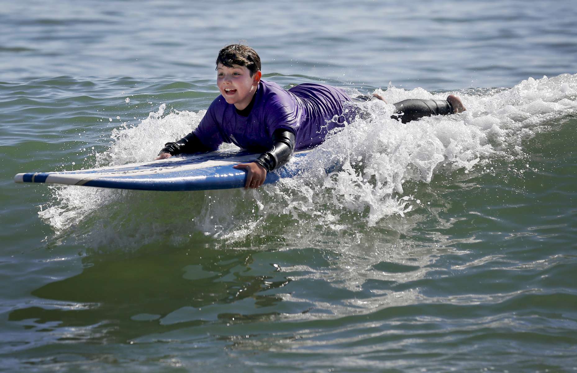 James Kaplan, 8, surfs a wave during a family trip Oct. 9, 1016 sponsored by Focus on Cancer in Santa Cruz, Calif. Sara, who survived kidney cancer, was sponsored by the company which works with cancer patients and survivors and their loved ones to provide support and special trips to reduce social isolation. 
