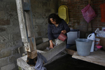 Maria Mendoza-Sanchez rinses a rag in a concrete wash basin behind her mother's home while doing chores around the house Sept. 28, 2017 in Santa Monica, Hidalgo, Mexico.