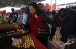 Maria Mendoza-Sanchez purchases vegetables with her husband, Eusebio Sanchez, right, and some of their family at a market near Santa Monica, Hidalgo, Mexico. 