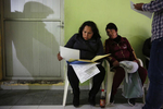 Maria Mendoza-Sanchez sits with family members and most of the neighborhood, including Paulina Vilchis, right, in a government office while trying to sort out paperwork relating to property she and her husband own nearby Sept. 27, 2017 near Mexico City, Mexico.