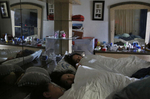 Sisters, from bottom left, Elizabeth, 16, Melin, 21, and Vianney Sanchez, 23, chat before falling asleep for the night in their parent's bedroom Sept. 12, 2017 in Oakland, Calif. The three began sharing their parent's bed once their parents and brother were deported to Mexico. Vianney says she is afraid that if something happens in the front of the house she won't hear it from her room and the three draw comfort from each other's company. 