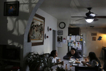 Sanchez sisters from left, Melin, 21, Elizabeth, 16, and Vianney, 23, eat dinner as they wait for their daily video call from their mother in Mexico Sept. 8, 2017 in their family home in Oakland.