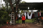 Maria Mendoza-Sanchez tries to get service on her cell phone to call her daughters as rain continues to pour down Oct. 1, 2017 in Santa Monica, Hidalgo, Mexico. The weather often interrupts internet and phone service, sometimes for days at a time, cutting her off from her daughters and the rest of the world.