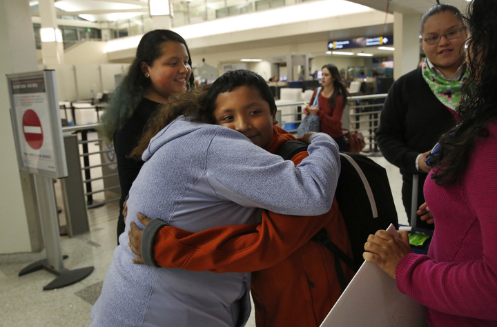 Vianney Sanchez, 23, hugs her little brother Jesus Sanchez, 12, after he arrived from Mexico in the Oakland International Airport as their sisters Elizabeth, 16, left, and Melin, 21, stand nearby Oct. 14, 2017 in Oakland, Calif. Their mother Maria Mendoza-Sanchez made the decision to send him back to the US after it was discovered that his paperwork hadn't gone through quickly enough for school and he would have to repeat the entire grade over again.