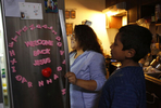 Vianney Sanchez, 23, gets food out of the fridge to make a favorite meal for her little brother Jesus Sanchez, 12, after getting home from the airport where he arrived from Mexico Oct. 14, 2017 in Oakland, Calif. Their mother Maria Mendoza-Sanchez made the decision to send him back to the US after it was discovered that his paperwork hadn't gone through quickly enough for school and he would have to repeat the entire grade over again.