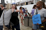 Heather Martin, of Columbine, left, hugs fellow mass shooting survivor Amanda Blomberg of Ft. Lauderdale Airport as Sherrie Lawson of DC Navy Yard looks on while Lawson and Martin pick people up for their annual survivor's gathering from Denver International Airport July 27, 2018, in Denver, Colorado, US.