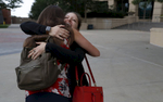 Fellow mass shooting survivors Becca La Creta, right, and Kristina Anderson, both of Virginia Tech, greet each other on their way into a private event for friends and family of Aurora Theater shooting survivors before the grand opening of the theater shooting's memorial July 27, 2018, in Aurora, Colorado, US.