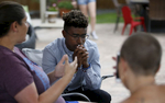 Mass shooting survivors Chad Williams, 18, center, and Michelle Wheeler, left, of Columbine, share stories about their experiences during the family dinner portion of the annual survivor's gathering with The Rebels Project July 28, 2018 in Parker, Colorado, US.