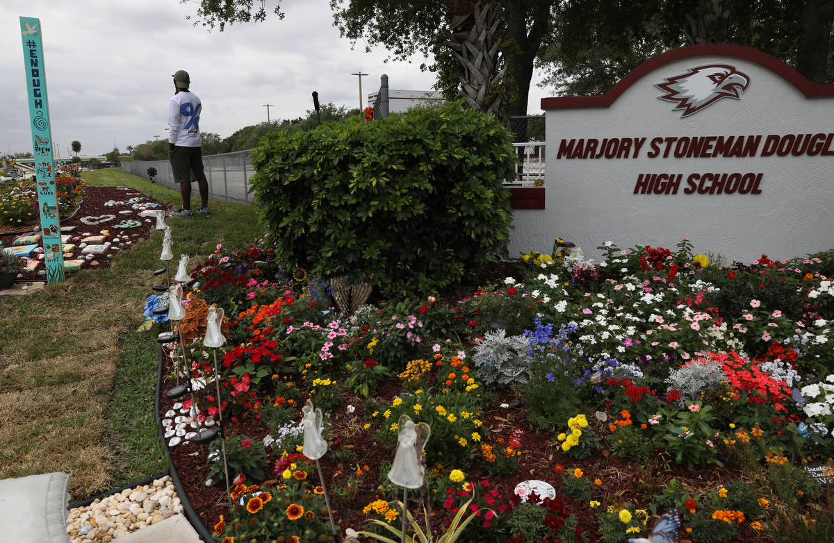 Chad Williams, 19, survivor and former student of Marjory Stoneman Douglas high school, stands alone at a memorial garden created by the girlfriend of Joaquin Oliver, who was was killed in the shooting and was also one of Williams' best friends, March 16, 2019 outside of Marjory Stoneman Douglas high school in Parkland, Florida, US. 