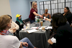 Heather Martin, center, a Columbine survivor, hands her The Rebels Project business card to Julie Gordon, Program Director at Eagles' Haven, a wellness center for the Marjory Stoneman Douglas community during a meeting with The Rebels Project members and two other mass trauma survivors at their new headquarters April 3, 2019 in Coral Springs, Florida, US. The center opened six weeks early after the recent apparent suicides by two Stoneman Douglas students.