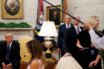 U.S. President Donald Trump ignores questions from reporters about Senator John McCain as news media are escorted from the room at the end of a photo opportunity with Kenya's President Kenyatta as first lady Melania Trump and White House Chief of Staff John Kelly look on in the Oval Office at the White House in Washington, U.S.