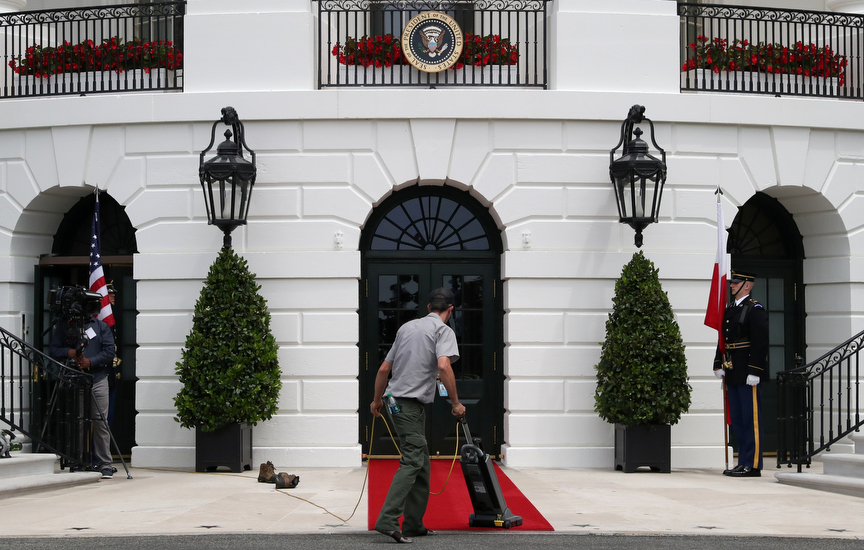 A worker vacuums the red carpet ahead of the arrival of Poland's President Andrzej Duda and his wife, Agata Kornhauser-Duda at the White House in Washington, U.S., June 12, 2019.