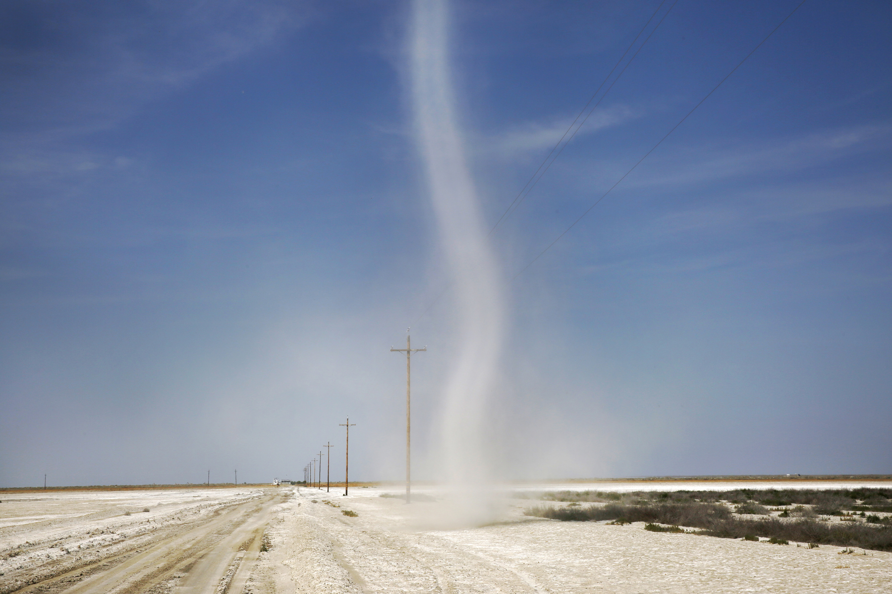 A dust devil makes its way across hot land made white from dried minerals as a result of the natural lake-bottom buildup and evaporation process April 10, 2015 near Kings County, Calif. The land is situated in part of the San Joaquin Valley that used to contain the Tulare Lake, the largest freshwater lake in the western half of the continental United States. The lake was dried up by the year 1900 due to emerging agriculture in the region.