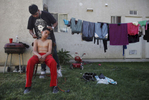 Abraham Tamayo, 12, gets his hair cut by Moises Tamayo, 20, outside of an apartment complex April 14, 2012 on the edge of town in Mendota, Calif. 
