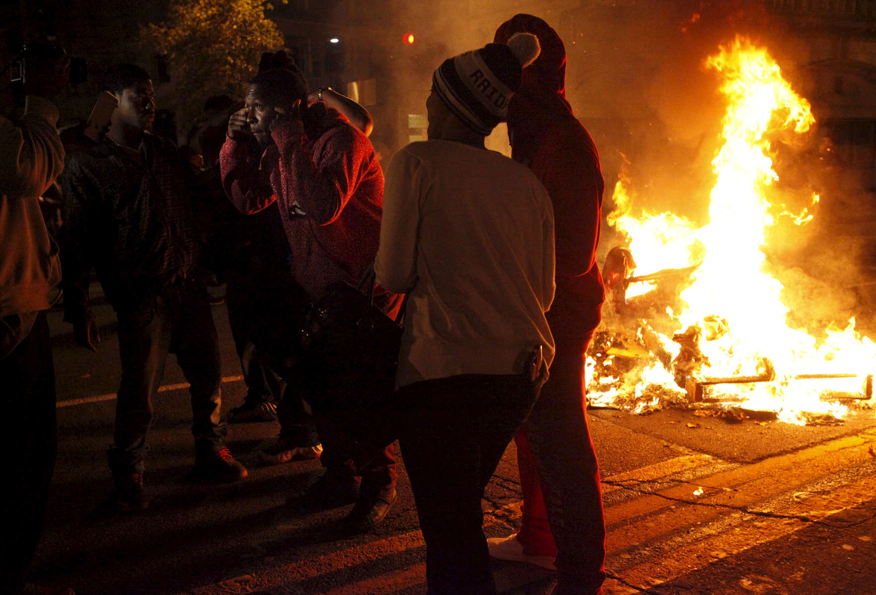 Musical artist Gaitta shoots a music video with others in front of another fire set near Broadway and Telegraph during a protest against the grand jury's decision not to indict the white police officer who fatally shot an unarmed black teenager months ago in Ferguson Nov. 24, 2014 in Oakland, Calif.