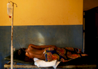 A woman in labor rest on a bed at the medical facility of Kuchigoro in Abuja, Nigeria.