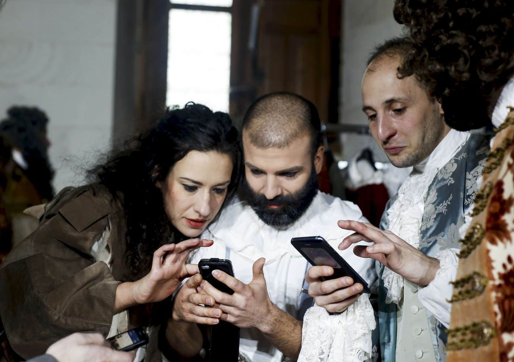 Melodie Veillard, Florent Robin, Romain Falik and Camille Ranciere check their cellphone as the last performance is being transmitted lived on Facebook.