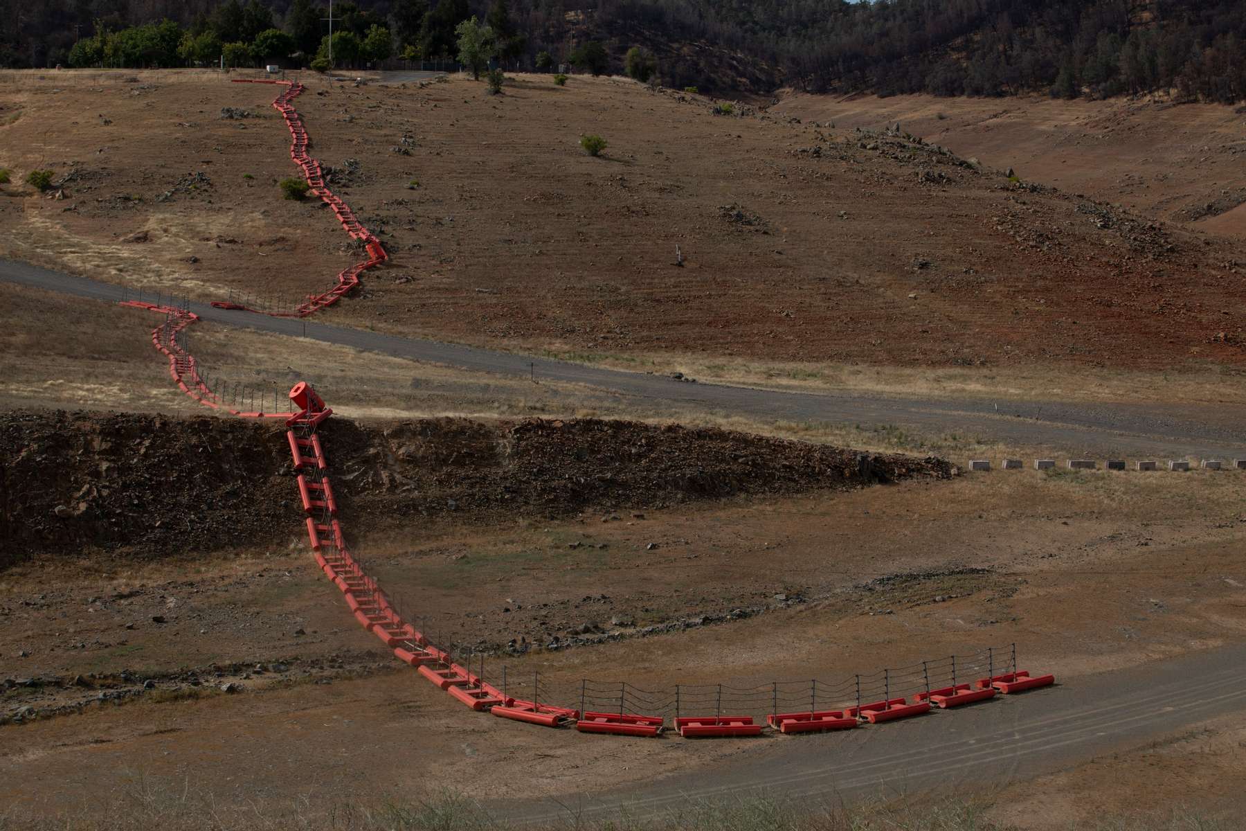 A floating security barrier is seen at a section that used to be underwater at Lake Oroville which is the second largest reservoir in California and according to daily reports of the state's Department of Water Resources is near 35% capacity, near Oroville, California, U.S., June 16, 2021. Picture taken June 16, 2021. 