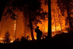 Firefighters work to protect houses from the Caldor fire on August 30, 2021, in South Lake Tahoe, California. The Caldor Fire has burned almost 200.000 acres, destroyed over 660 structures and is currently 16 percent contained. 