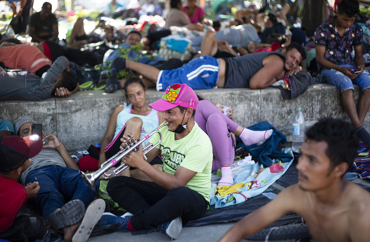 A migrant plays trumpet while resting with others migrants after a very early walk  in Chahuites, Mexico November 8, 2021. 