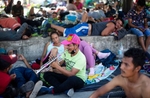 A migrant plays trumpet while resting with others migrants after a very early walk  in Chahuites, Mexico November 8, 2021. 