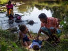 A family takes a bath in the river after a very early walk  in Chahuites, Mexico November 8, 2021. 