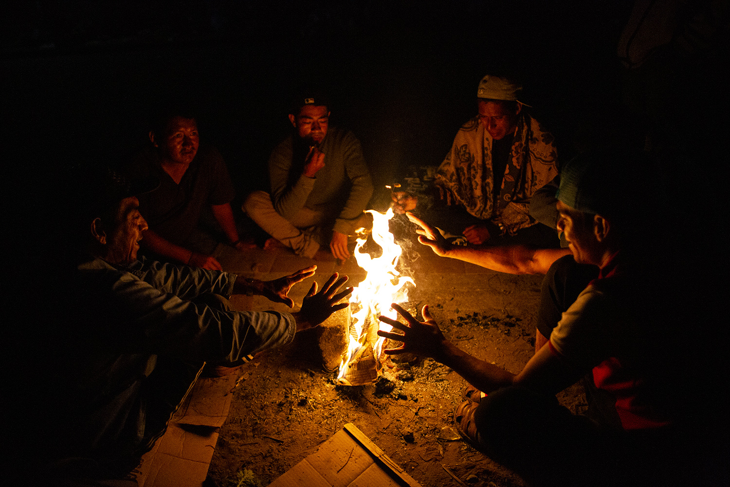 Migrants warm themselves with a fire before an early walk in Santo Domingo Zanatepec, Mexico November 10, 2021.