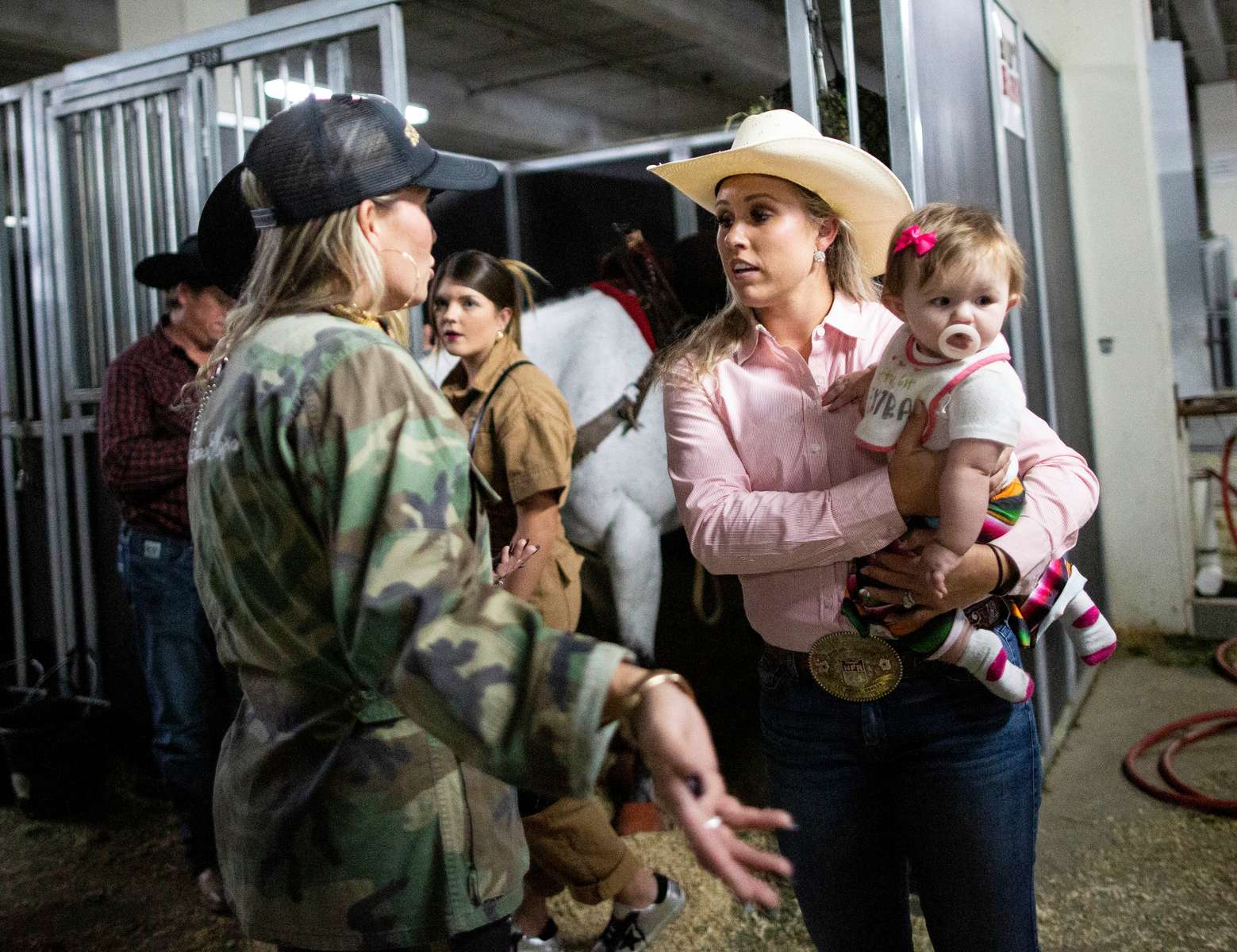 Cassidy Deen, holding her baby, speaks with other participants before participating in the Barrel Racing semi-finals of the Women's Rodeo World Championship at the South Point Arena, in Las Vegas, Nevada, U.S., October 29, 2021.  Picture taken on October 29, 2021. 