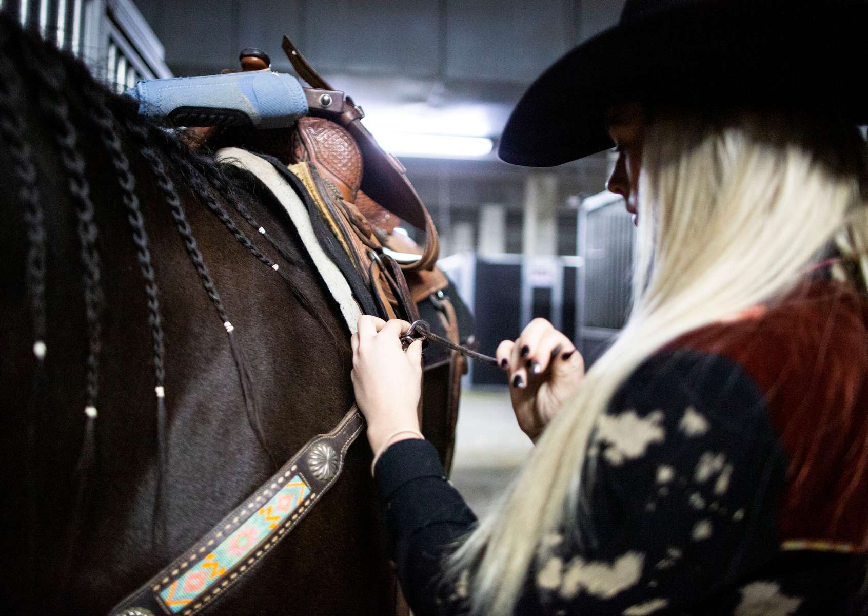 Acey Pinkston prepares her horse before participating in the Barrel Racing semi-finals of the Women's Rodeo World Championship at the South Point Arena, in Las Vegas, Nevada, U.S., October 29, 2021.  