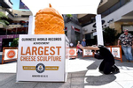 IMAGE DISTRIBUTED FOR THE MELT - Kyler Clark of Georgia pays homage to THE MELT's GUINNESS WORLD RECORDS® Largest cheese sculpture on Sept. 18, 2015, in celebration of National Cheeseburger Day. The Melt partnered with renowned cheese sculptor Troy Landwehr to create the 1,524 pound, record-breaking sculpture, fittingly carved in the shape of a cheeseburger, complete with a pickle on top. (Photo by Jordan Strauss/Invision for The Melt/AP Images)
