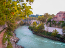 This is an image of the Tiber River Walk, Rome, Italy.  The Tiber is the third-longest river in Italy, rising in the Apennine Mountains in Emilia-Romagna and flowing 406 kilometres (252 mi) through Tuscany, Umbria and Lazio, where it is joined by the river Aniene, to the Tyrrhenian Sea, between Ostia and Fiumicino.[3] It drains a basin estimated at 17,375 square kilometres (6,709 sq mi). The river has achieved lasting fame as the main watercourse of the city of Rome, founded on its eastern banks.As the Tiber River winds through Rome, Italy, pedestrians can stroll along at the level of the river itself or on the streets above the walls that protect Rome from flooding.  At each bridge, you will find stairs that lead down to the path. (This is best done on the Trastevere side of the river, where the bike path has been developed).From the north, one passes a number of bridges including the Umberto I Bridge (Ponte Umberto I) that leads to the Palace of Justice, the Sant’Angelo Bridge (ponte Sant’Angelo) leading to Castel Sant’Angelo, the Victor Emmanuel II Bridge (Ponte Vittorio Emanuele II) and the Prince Amedeo Bridge (Ponte Principe Amedeo) just below Castel Sant’Angelo, the Giuseppe Mazzini Bridge (Ponte Mazzini) with its fascinating lamps, and the Palatino Bridge (Ponto Palatino) and the ruins of the Rotto Bridge (Ponte Rotto), just below the rapids.