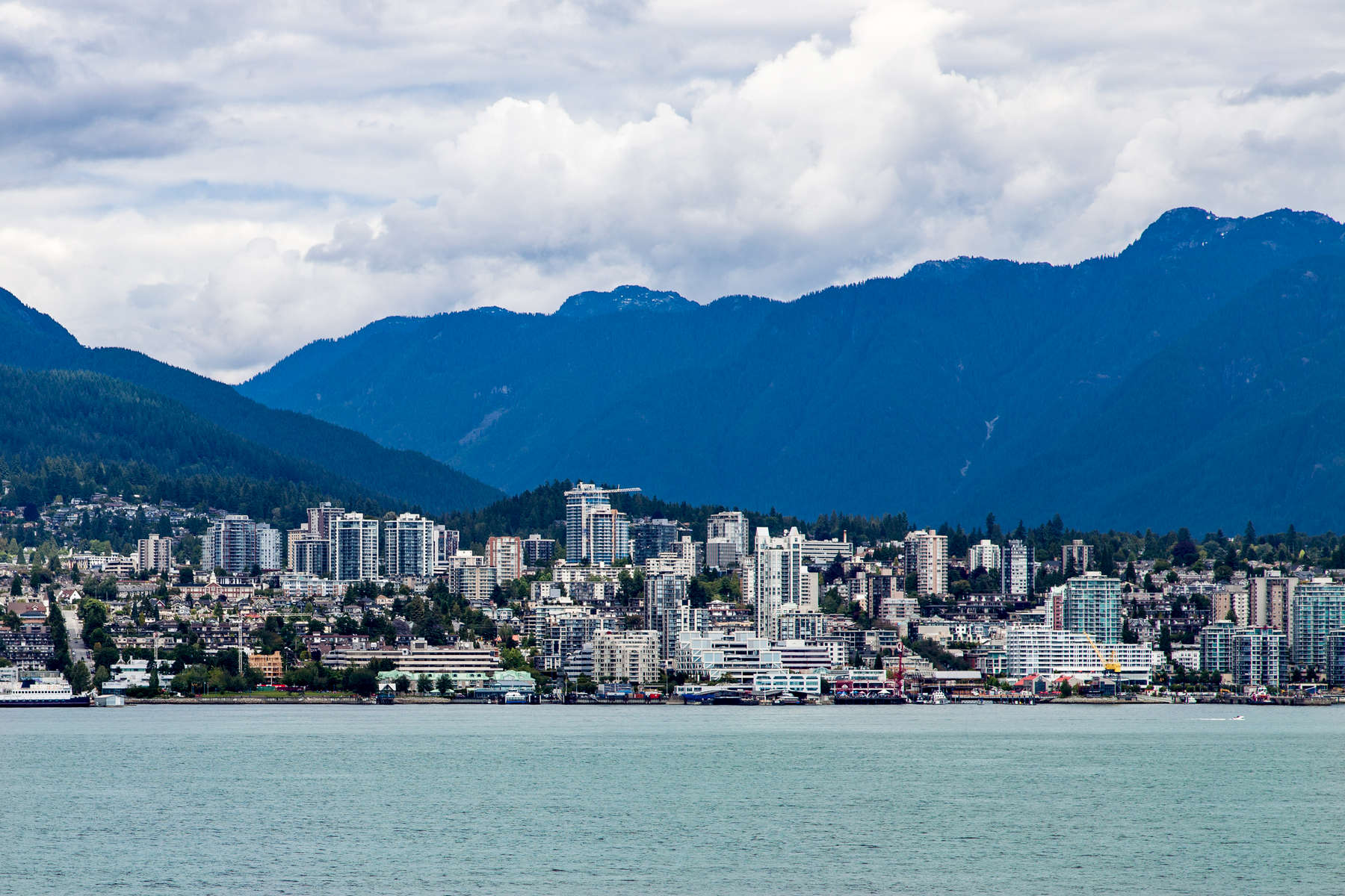 Vancouver, British Columbia, a bustling seaport, is located on the Burrard Peninsula,  The North Shore Mountains dominate the cityscape.   Vancouver is a coastal seaport city in western Canada, located in the Lower Mainland region of British Columbia. As the most populous city in the province, the 2016 census recorded 631,486 people in the city, up from 603,502 in 2011. The Greater Vancouver area had a population of 2,463,431 in 2016, making it the third-largest metropolitan area in Canada. Vancouver has the highest population density in Canada with over 5,400 people per square kilometer, which makes it the fourth-most densely populated city with over 250,000 residents in North America behind New York City, San Francisco, and Mexico City according to the 2011 census. Vancouver is one of the most ethnically and linguistically diverse cities in Canada according to that census; 52% of its residents have a first language other than English.