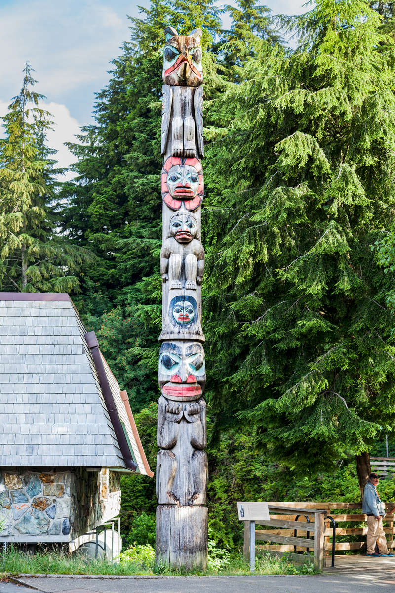 Ketchikan, Alaska - Located in front of the Ketchikan Public Library, the Raven Stealing the Sun Totem Pole is a Native legend/Story pole.According to legend, the story is about an old chief & his daughter. It is said that the chief kept the sun hidden away in a box. Raven wanted to have this sun and had tried to get it many times without success. He noticed that the daughter went to the well every day for water, so he transformed himself into a pine needle, dropped into her water and was swallowed. She became pregnant and in due time Raven was reborn as the chief's grandson.Raven became the old chief's favorite and let him have anything he asked for. One day he asked to play with the sun box, but he refused. Raven cried & cried and finally his grandfather let him play with it. Raven quickly took the box and rolled it outside. Then dashing the box to pieces, he took the sun in his beak and placed it in the sky, where it has been giving light to the world ever since.