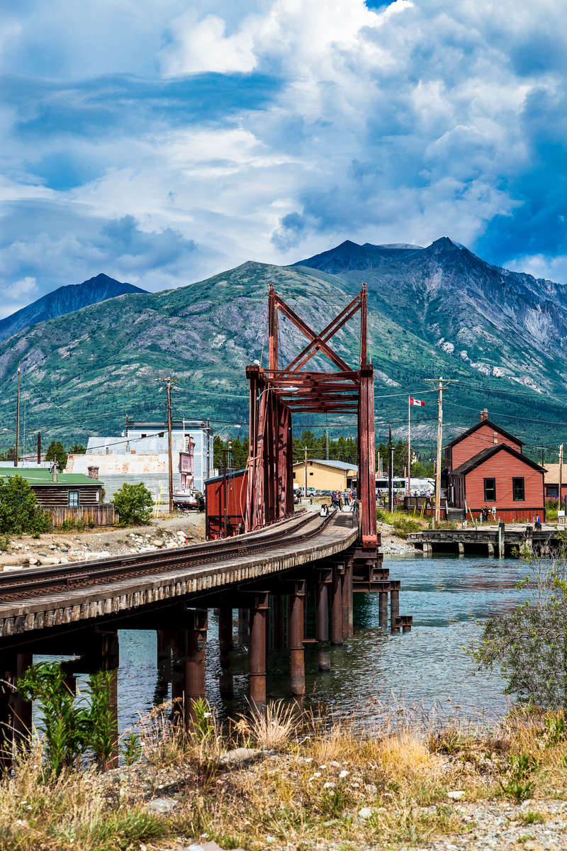 At Bennett Lake in Carcross, Canada.  The White Pass and Yukon Route station house and rail bridge over the strait between Bennett Lake and Nares Lake in Carcross, Yukon. Caribou Mountain is in the background.