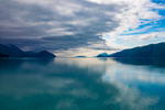 Glacier Bay, Alaska is located within of the Alexander Archipelago, which is a 300 miles long group of islands, of North America off the southeastern coast of the Gulf of Alaska.  It contains about 1,100 islands, which are the tops of the submerged coastal mountains that rise steeply from the Pacific Ocean. Deep channels and fjords separate the islands and cut them off from the mainland. The islands shelter the northern part of the Inside Passage as it winds its way among them.About this image:  Although this Image was taken shortly after 12 noon, the scene has the tranquil feel of dusk due to storm clouds rolling in over the fjords