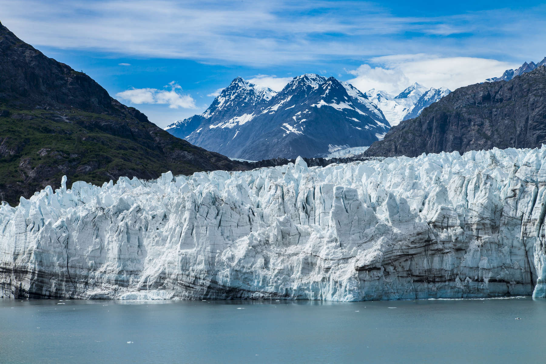 Margerie Glacier is a relatively stable tidewater glacier in Glacier Bay, Alaska, within the boundaries of Glacier Bay National Park and Preserve.  Margerie is about 21 miles long, 1 mile wide, with an ice face that is about 250 feet high above the waterline.  The glacier begins on the southern slopes of Fairweather Mountain's, Mount Root, an elevation of 12,860 feet (3,920 m), on the Alaska–Canada border flowing southeast down the valley, then turning to the northeast toward its terminus in Tarr Inlet. Margerie Glacier is one of the most active and frequently visited glaciers in Glacier Bay. The glacial ice appears blue as a result of the absorption of red, orange, yellow and green wavelengths of light and, consequently, pools of melt-water on top of the glacier will appear bright blue.