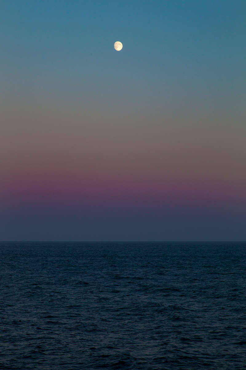 An eerie sense of timelessness comes over seafaring travellers near Seward, Alaska as faint rays from the midnight sun glimmer on the horizon, and a glint of moonlight kisses the waves.  Photo was taken at 1:50 AM on July 17, 2016.