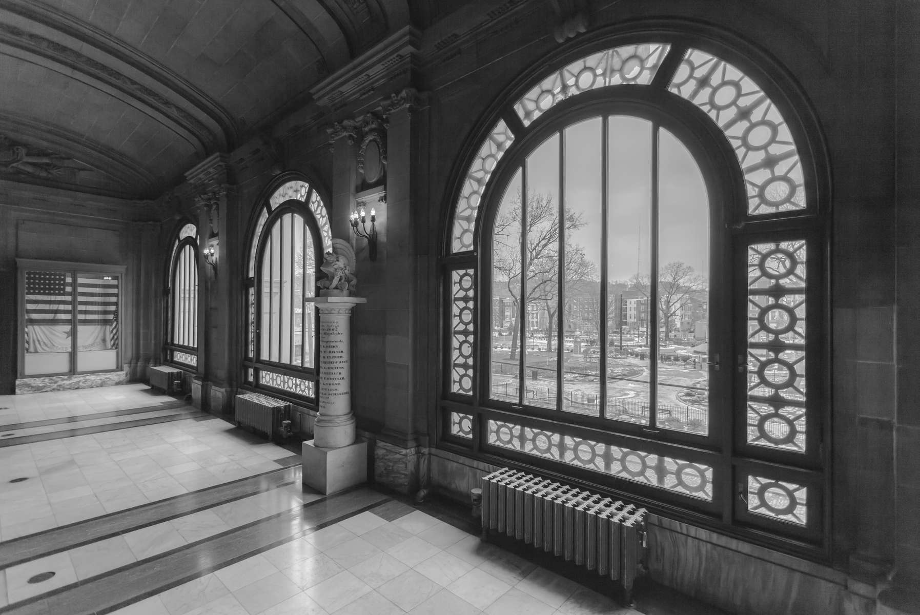 Memorial Hall OTR Cincinnati, OH.  Image from corridor outside gallery entrances highlighting beautiful arched windows overlooking Washington Park, and the United States flag as a memorial to the military of the city and county.