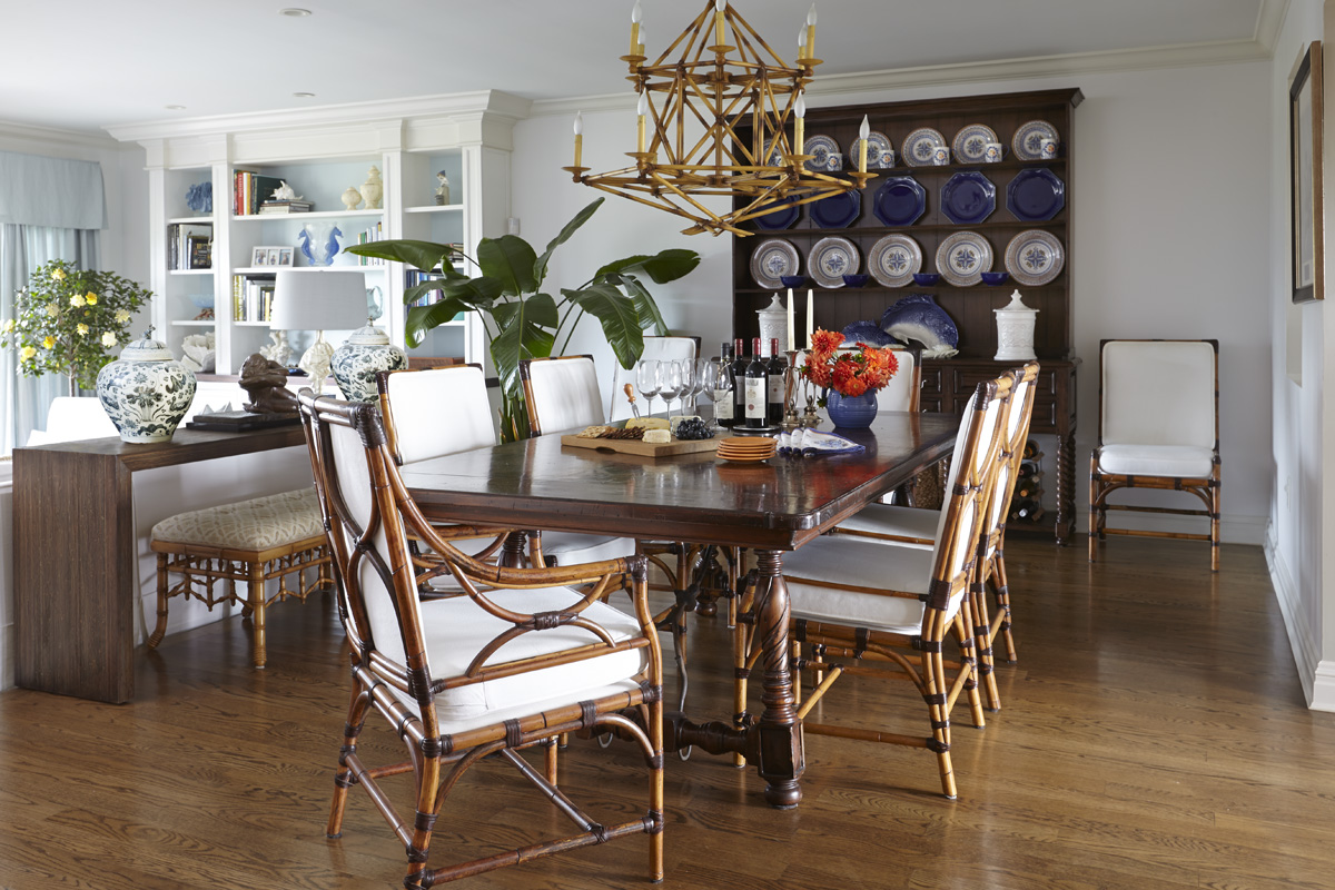 Dining Room Design  with spanish style table juxtaposes the light bamboo chairs and chandelier above.