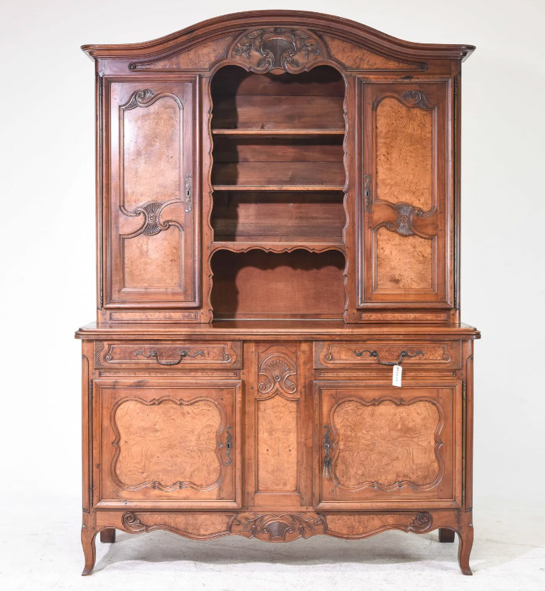 This elegant French double buffet features beautiful walnut and burl wood. It has double-panel doors on both the upper and lower sections, each adorned with intricate iron escutcheons and original iron fiche hinges. The buffet also includes two central drawers with original iron pulls. A scalloped edge runs along the base, and it retains its original finish.65” x 21” x 91”Our Price $5,200