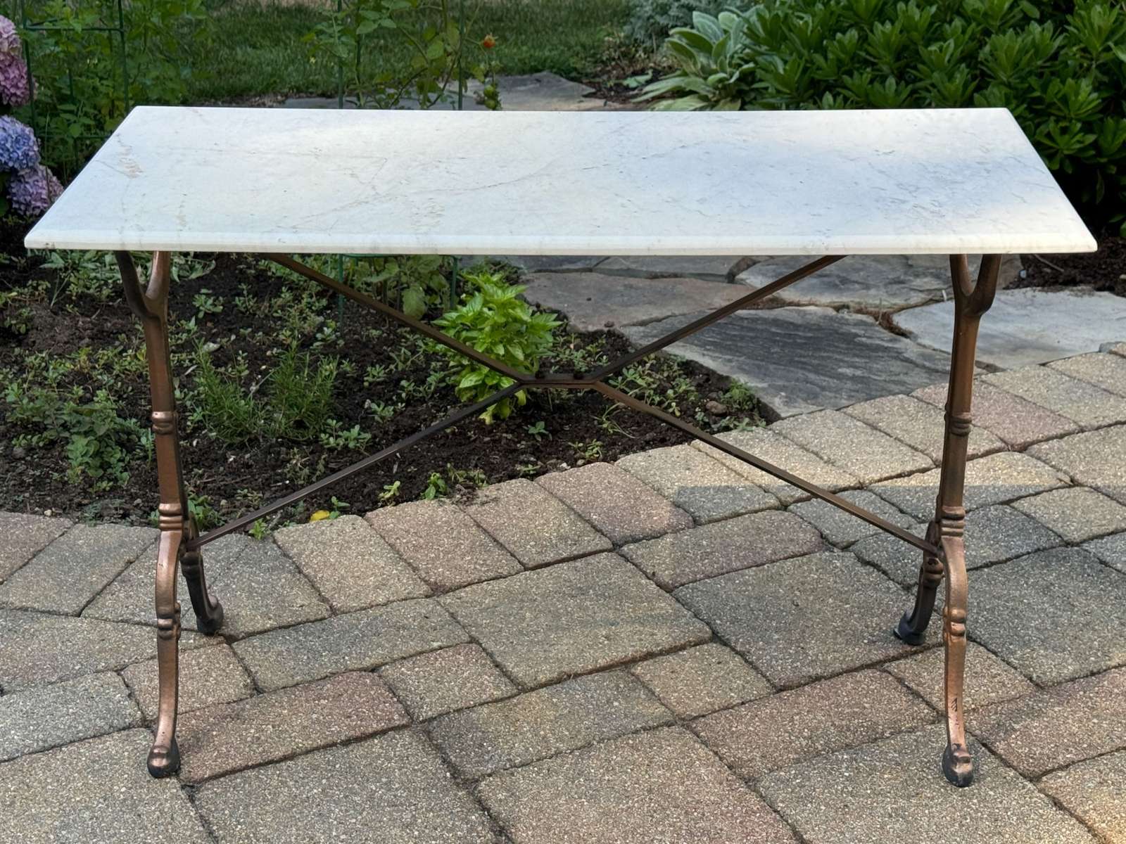 This elegant French café table features a rectangular white marble top, supported by a cast-iron trestle base with a gilt finish. The cabriole legs have refined scrolled borders and are reinforced by a wide X-shaped stretcher that extends from the legs to the tabletop.28{quote} H x 19 1/4{quote} D x 42{quote} LOur Price $850