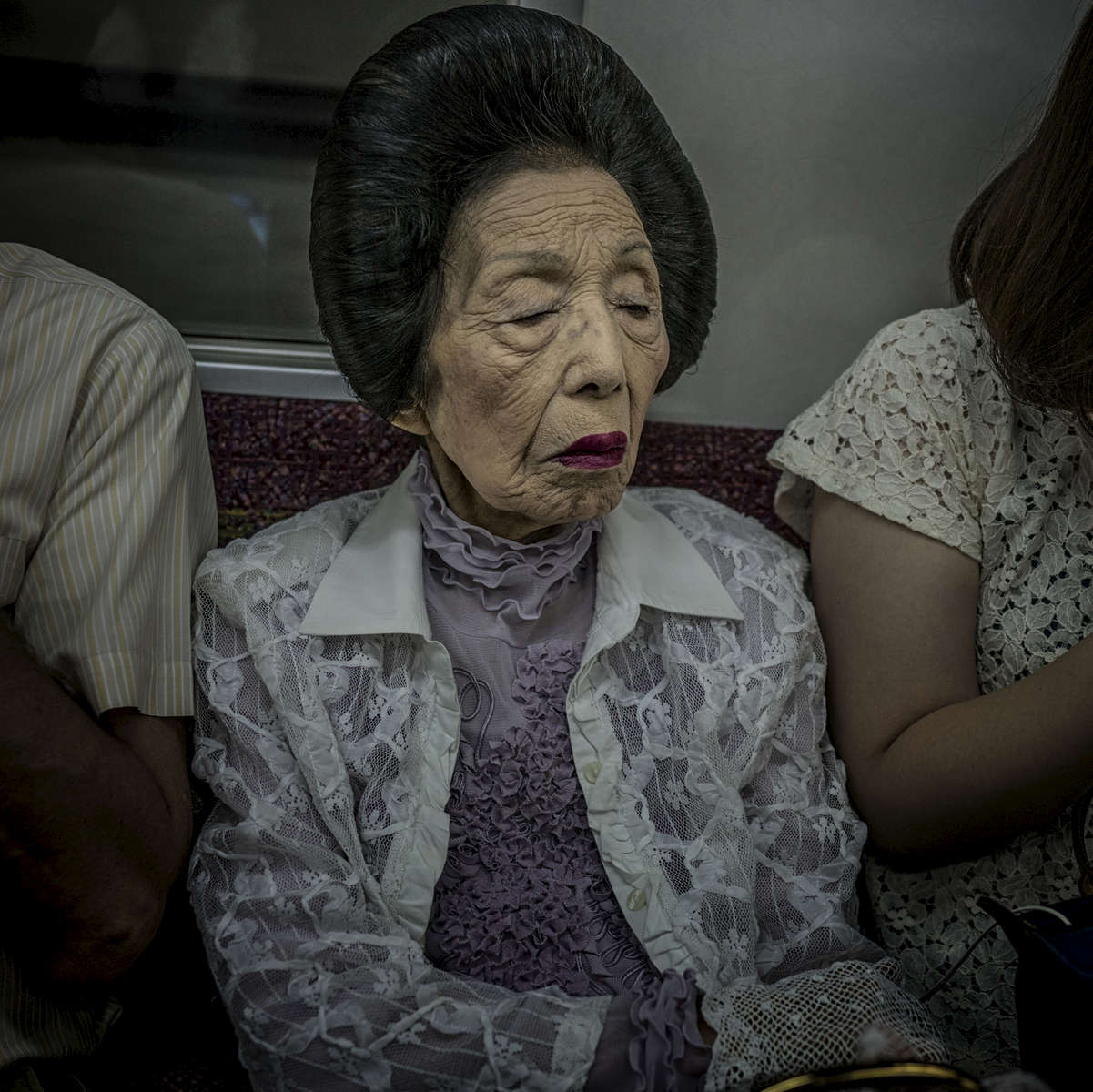 Matriarch with gloves and red lipstick on the train in Tokyo.  Japan.