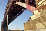 Kenneth Cuesta, 21, and Lisa Wong, 21, of Forest Hills, Queens, kiss as they watch the sunset under the Hell Gate Bridge located at Shore Boulevard in Astoria, New York on March 17, 2010.